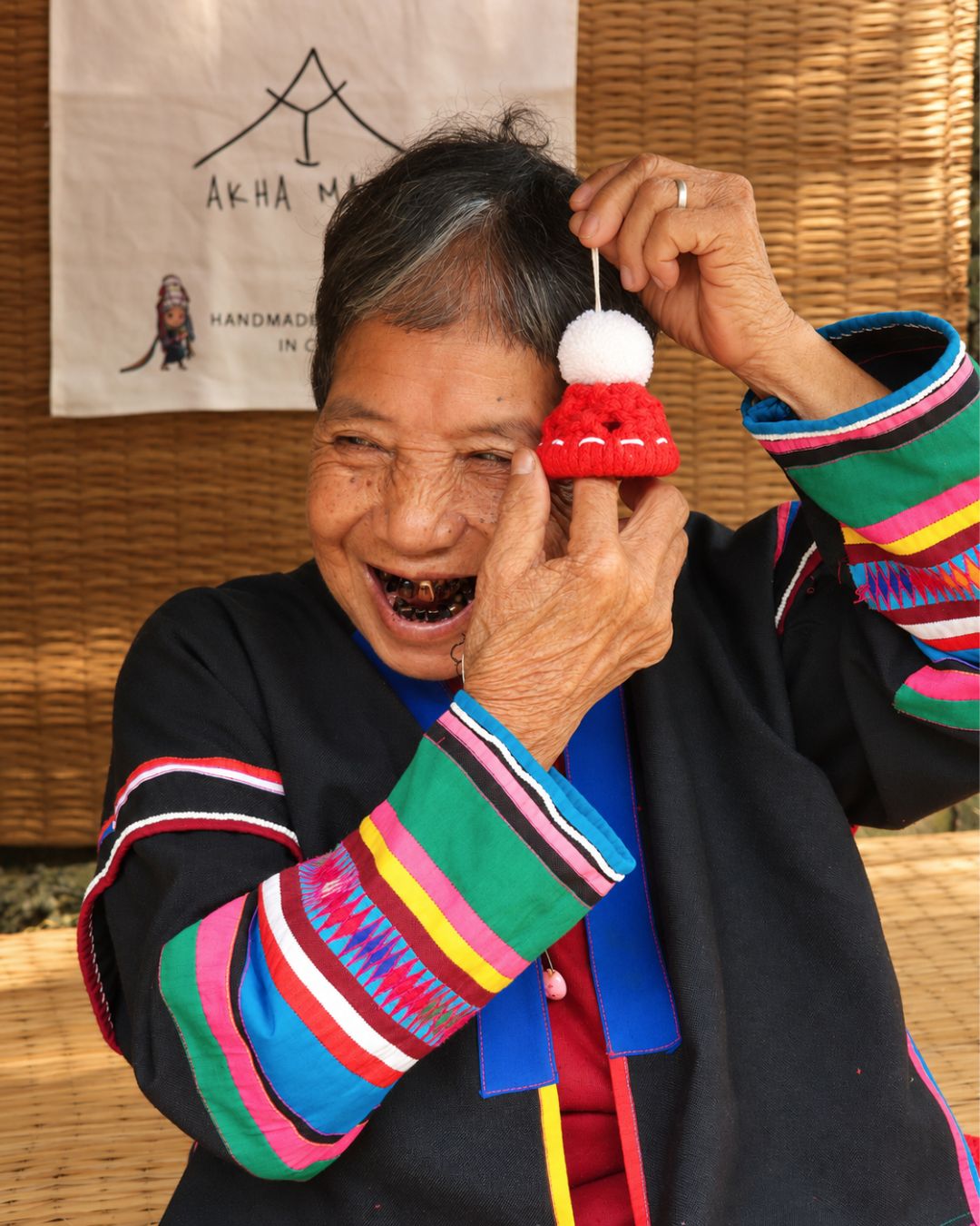 Api Minium smiling and holding a red cotton ornament